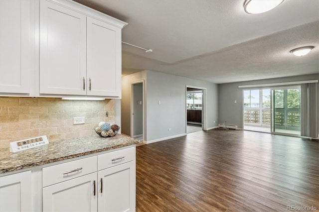 kitchen featuring light stone countertops, a textured ceiling, white cabinetry, a baseboard heating unit, and backsplash