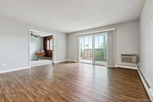 empty room with wood-type flooring, baseboard heating, and a textured ceiling