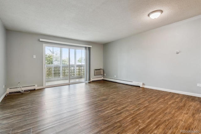 empty room featuring a wall mounted air conditioner, a baseboard radiator, a textured ceiling, and wood-type flooring