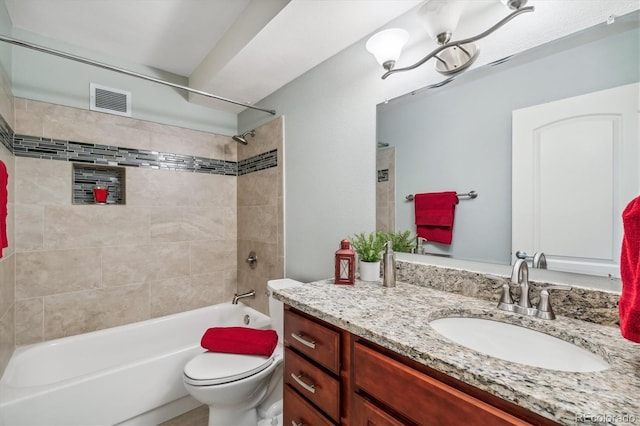 full bathroom with tiled shower / bath combo, toilet, and vanity