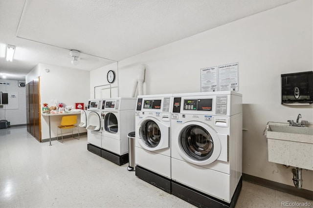 clothes washing area with separate washer and dryer and sink