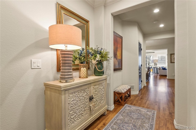 hallway featuring dark wood-style floors, recessed lighting, visible vents, and baseboards