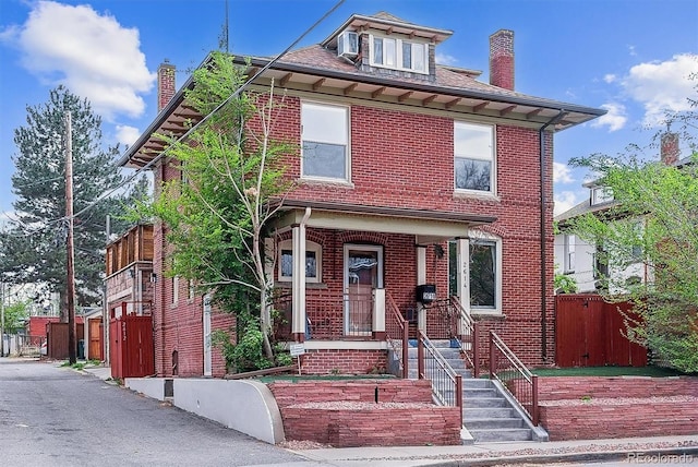 traditional style home featuring fence, a chimney, and brick siding