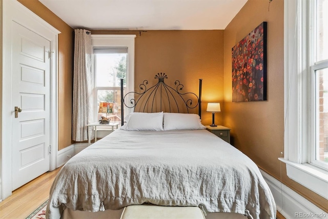 bedroom featuring multiple windows and wood finished floors