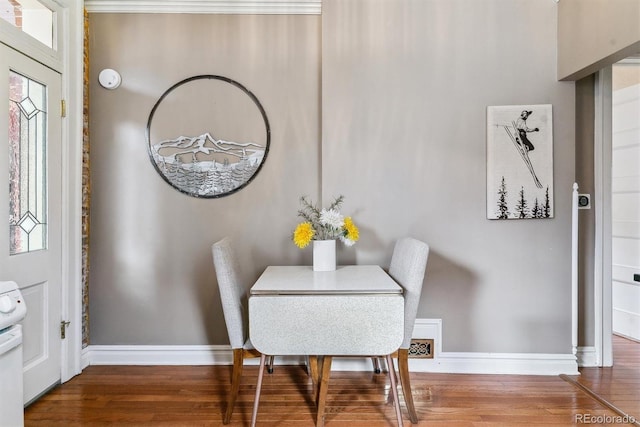 dining space featuring baseboards and wood finished floors