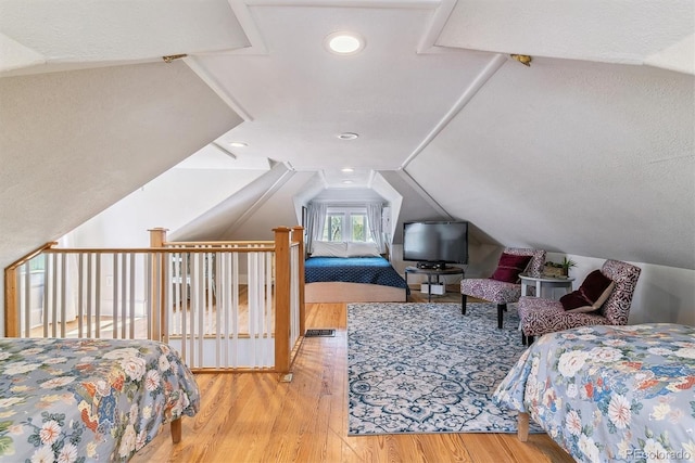 bedroom with vaulted ceiling, wood finished floors, and visible vents