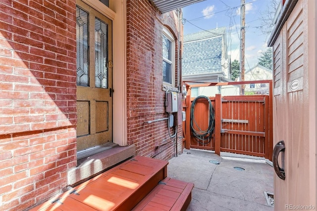 view of side of property with brick siding and fence