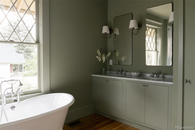 3330 Bruce Randolph Ave, Denver, CO 80205 - bathroom with a freestanding bath, double vanity, and wood finished floors