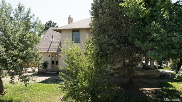 3330 Bruce Randolph Ave, Denver, CO 80205 - back of property featuring a chimney and a shingled roof