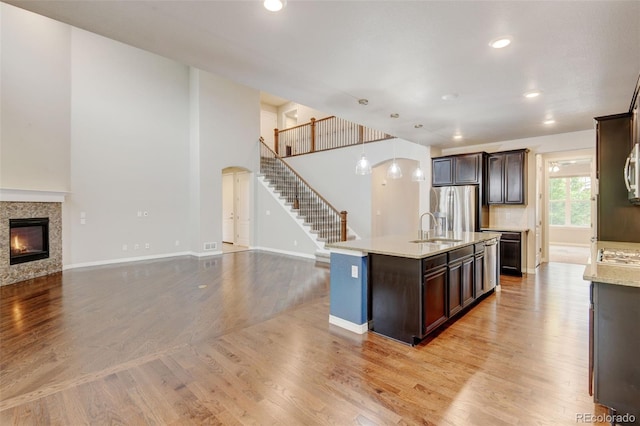 2454 Ambience Ln, Castle Rock, CO 80109 - kitchen with stainless steel refrigerator with ice dispenser, a sink, open floor plan, dark brown cabinets, and recessed lighting