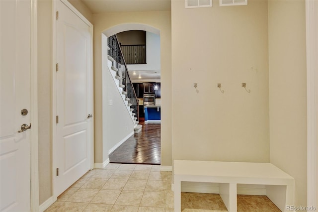 2454 Ambience Ln, Castle Rock, CO 80109 - mudroom featuring arched walkways, baseboards, and tile patterned floors