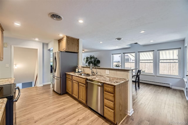 3245 S Kendall St, Denver, CO 80227 - kitchen with stainless steel appliances, a baseboard radiator, light wood finished floors, brown cabinetry, and light stone countertops