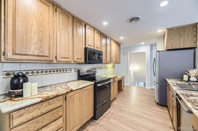 3245 S Kendall St, Denver, CO 80227 - kitchen with black appliances, tasteful backsplash, light wood-style flooring, light stone counters, and recessed lighting
