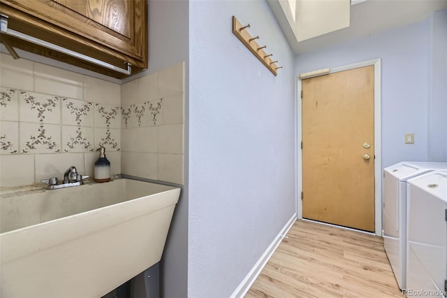 3245 S Kendall St, Denver, CO 80227 - washroom featuring light wood-type flooring, washer and clothes dryer, a skylight, and cabinet space