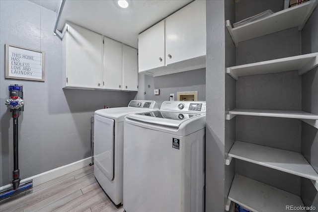 laundry area with cabinet space, washer and dryer, baseboards, and light wood-style flooring