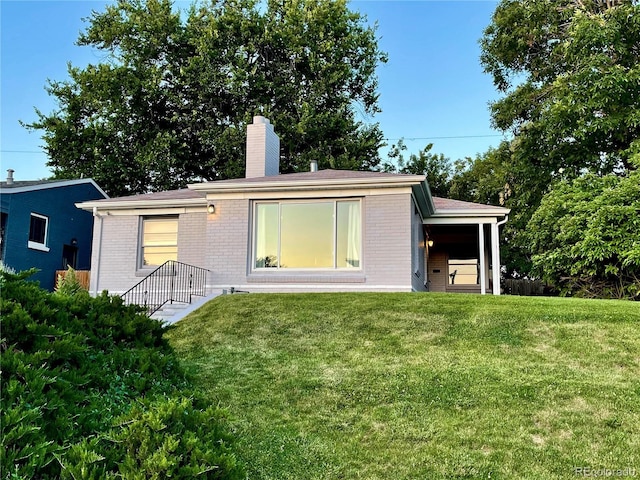 2626 N Steele St, Denver, CO 80205 - back of property with brick siding, a chimney, and a lawn
