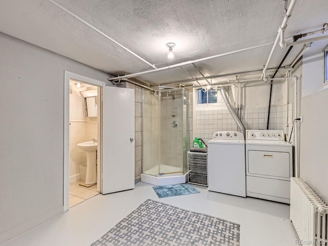 2626 N Steele St, Denver, CO 80205 - washroom with radiator heating unit, washing machine and dryer, a textured ceiling, and tile walls