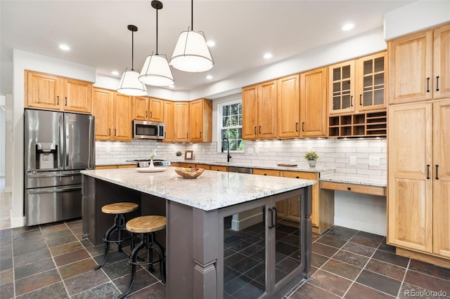 2037 River W Dr, Windsor, CO 80550 - kitchen featuring appliances with stainless steel finishes, a center island, stone tile flooring, light stone counters, and backsplash