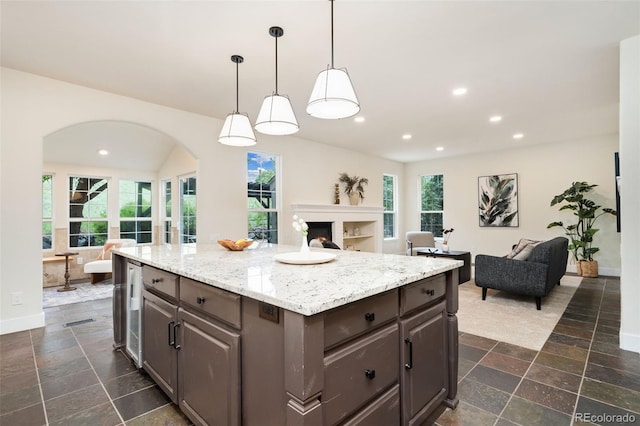 2037 River W Dr, Windsor, CO 80550 - kitchen with open floor plan, arched walkways, recessed lighting, and stone tile floors
