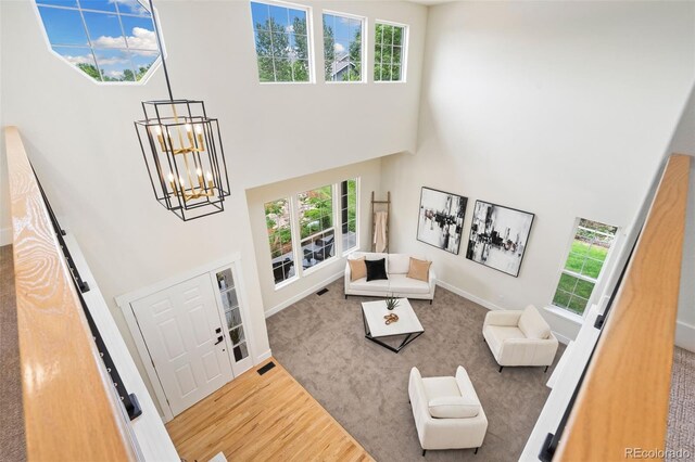 2037 River W Dr, Windsor, CO 80550 - living area featuring a high ceiling, wood finished floors, and a chandelier