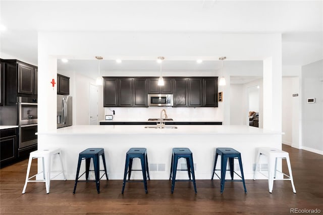 14454 Grape Way, Thornton, CO 80602 - kitchen featuring stainless steel appliances, a sink, a breakfast bar area, light countertops, and pendant lighting