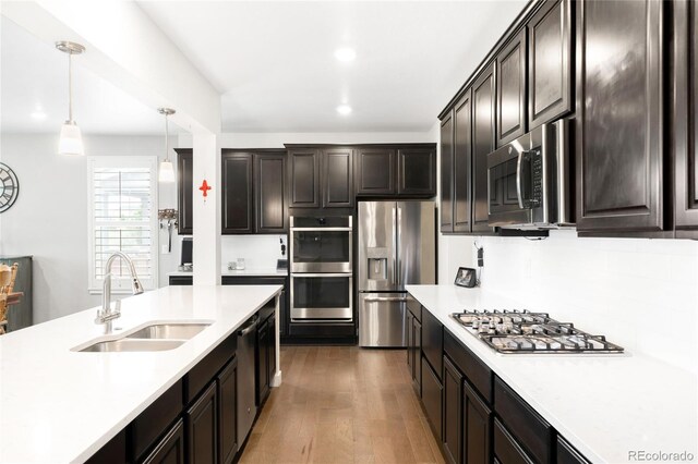 14454 Grape Way, Thornton, CO 80602 - kitchen with stainless steel appliances, a sink, light countertops, dark wood-type flooring, and recessed lighting