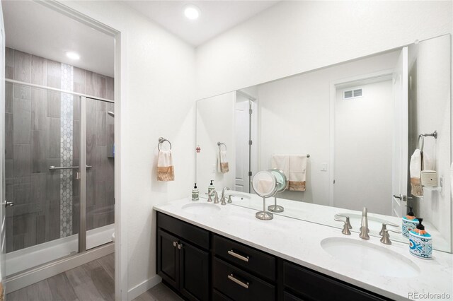 14454 Grape Way, Thornton, CO 80602 - bathroom featuring double vanity, a stall shower, and wood finished floors
