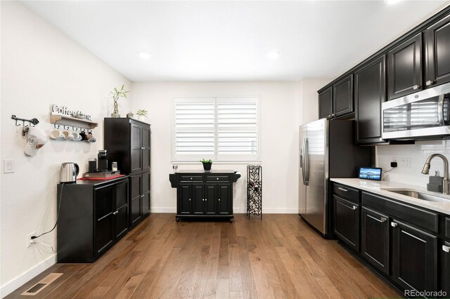 14454 Grape Way, Thornton, CO 80602 - kitchen featuring stainless steel appliances, a sink, baseboards, dark cabinets, and recessed lighting
