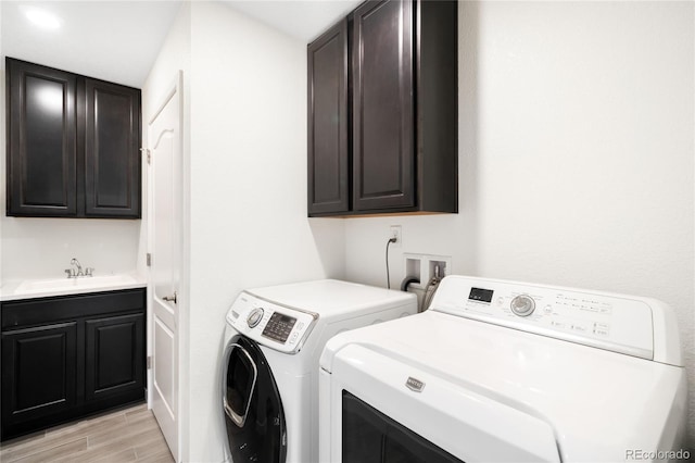 14454 Grape Way, Thornton, CO 80602 - laundry room with cabinet space, washer and dryer, and light wood finished floors