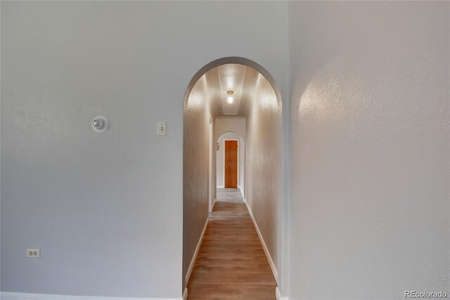 4514 Bryant St, Denver, CO 80211 - hallway with arched walkways, light wood-type flooring, and baseboards