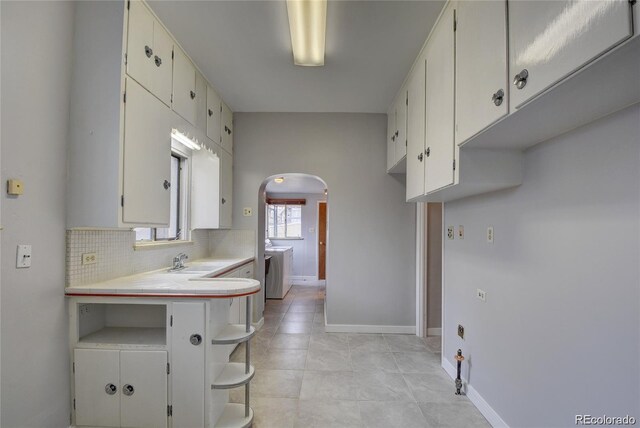 4514 Bryant St, Denver, CO 80211 - kitchen with arched walkways, light countertops, a sink, tasteful backsplash, and baseboards
