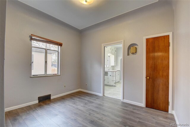 4514 Bryant St, Denver, CO 80211 - unfurnished bedroom featuring wood finished floors, connected bathroom, and baseboards
