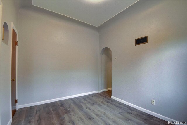 4514 Bryant St, Denver, CO 80211 - unfurnished room featuring arched walkways, baseboards, and dark wood finished floors