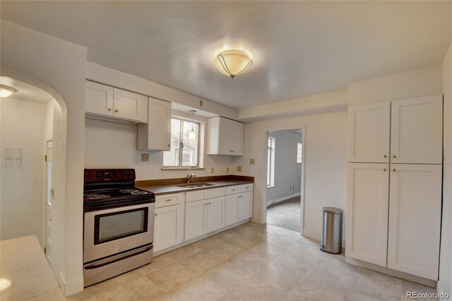 4514 Bryant St, Denver, CO 80211 - kitchen with stainless steel range with electric cooktop, a sink, healthy amount of natural light, and white cabinets