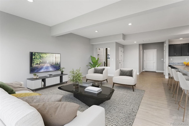 living room featuring beam ceiling and light hardwood / wood-style floors