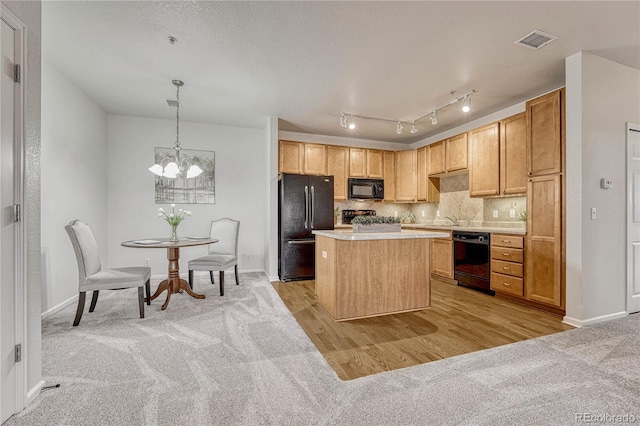 kitchen featuring an inviting chandelier, a center island, hanging light fixtures, light colored carpet, and black appliances