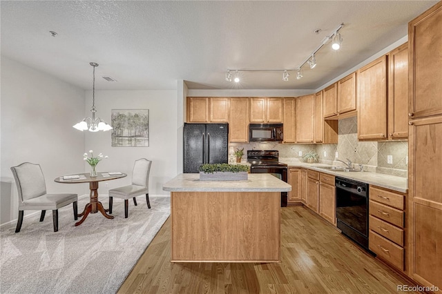 kitchen with a kitchen island, decorative light fixtures, light hardwood / wood-style floors, black appliances, and light brown cabinets