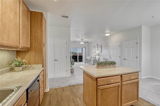 kitchen featuring tasteful backsplash, light hardwood / wood-style flooring, stainless steel dishwasher, a kitchen island, and ceiling fan