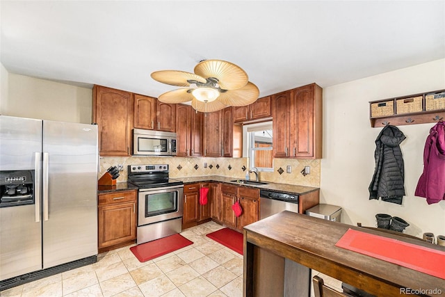 kitchen with tasteful backsplash, appliances with stainless steel finishes, sink, and light tile patterned floors