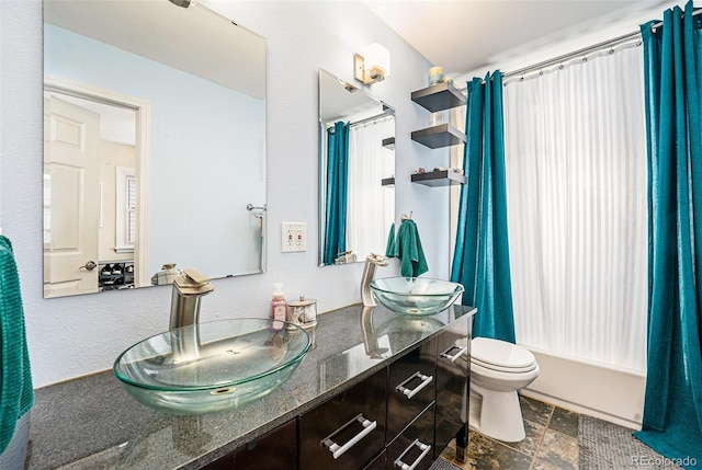 full bathroom featuring vanity, shower / bath combination with curtain, and toilet