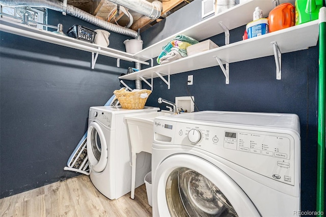 laundry area with washing machine and dryer and hardwood / wood-style floors