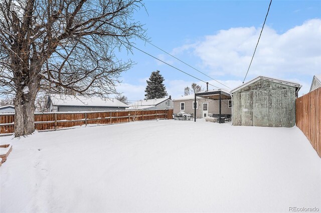 yard covered in snow with a storage shed