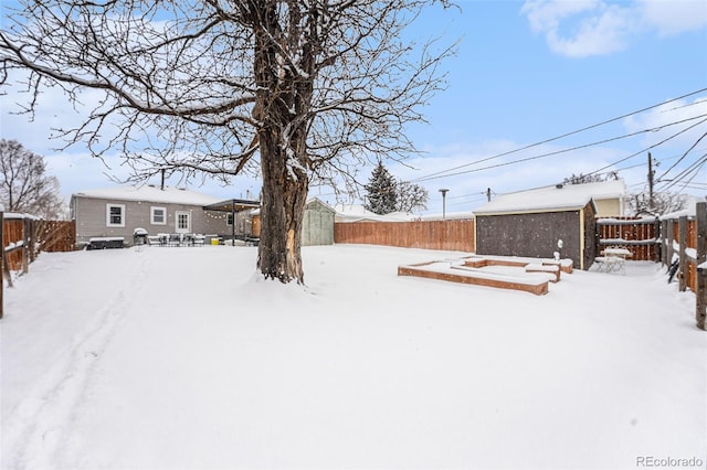 yard layered in snow with an outbuilding