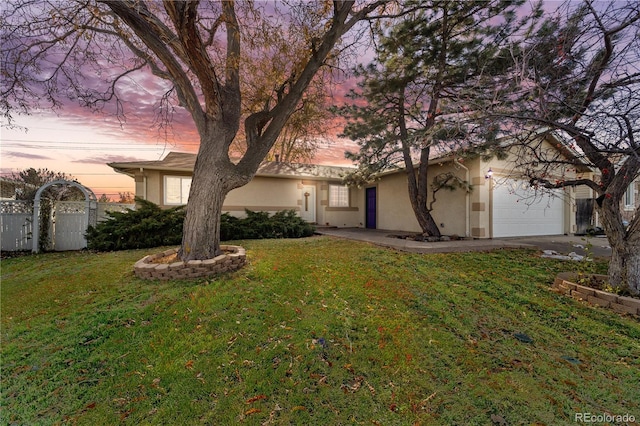 view of front of property featuring a lawn and a garage