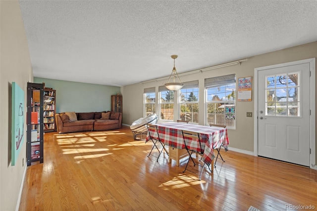 dining area featuring a textured ceiling and light wood-type flooring