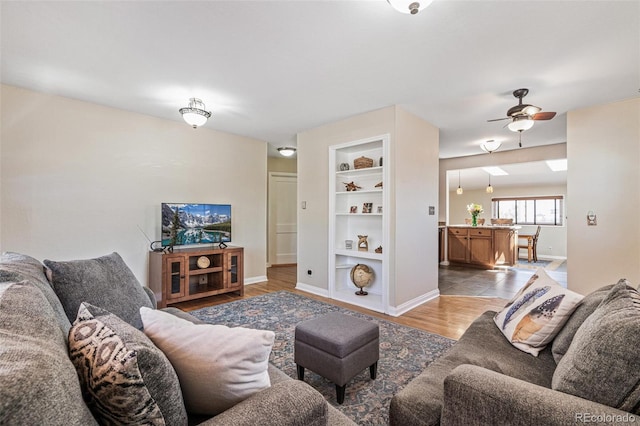 2252 Lamar St, Edgewater, CO 80214 - living area with a ceiling fan, baseboards, built in shelves, and light wood-type flooring