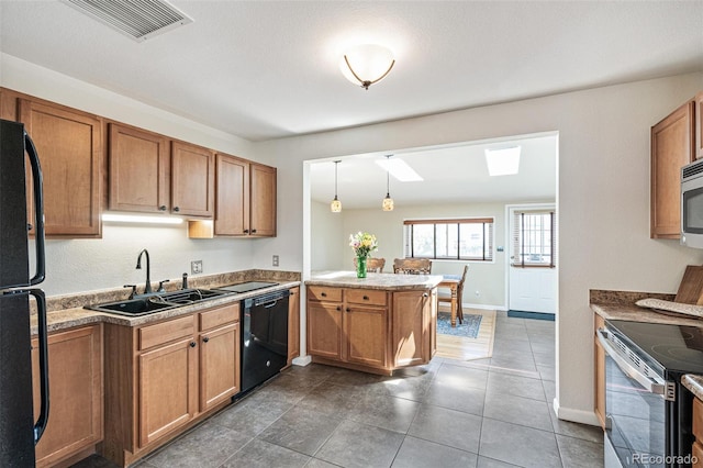 2252 Lamar St, Edgewater, CO 80214 - kitchen with black appliances, a sink, a peninsula, brown cabinets, and a skylight