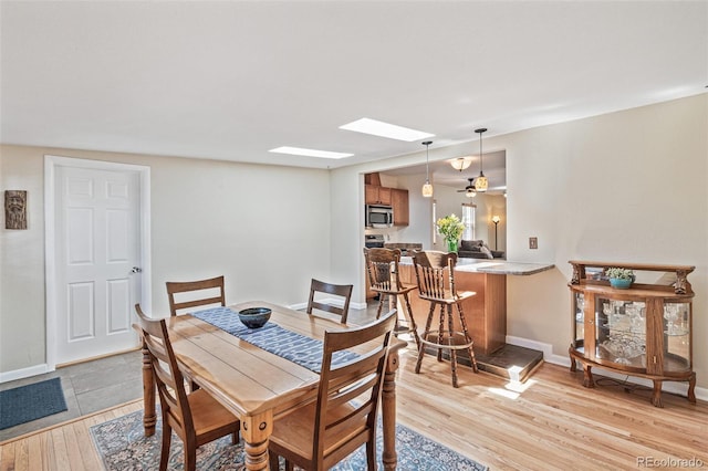 2252 Lamar St, Edgewater, CO 80214 - dining room with a skylight, light wood-style flooring, and baseboards