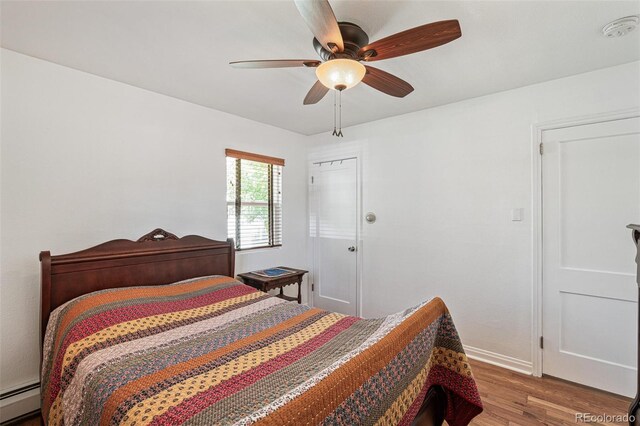 2252 Lamar St, Edgewater, CO 80214 - bedroom with baseboard heating, wood finished floors, baseboards, and a ceiling fan