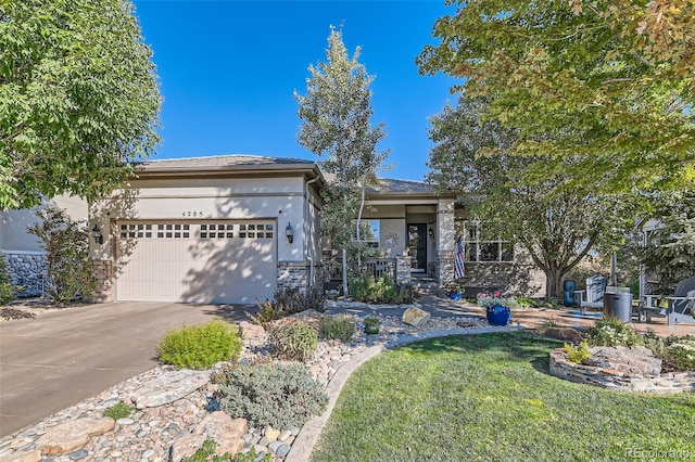 prairie-style house featuring a garage, driveway, a front lawn, and stucco siding